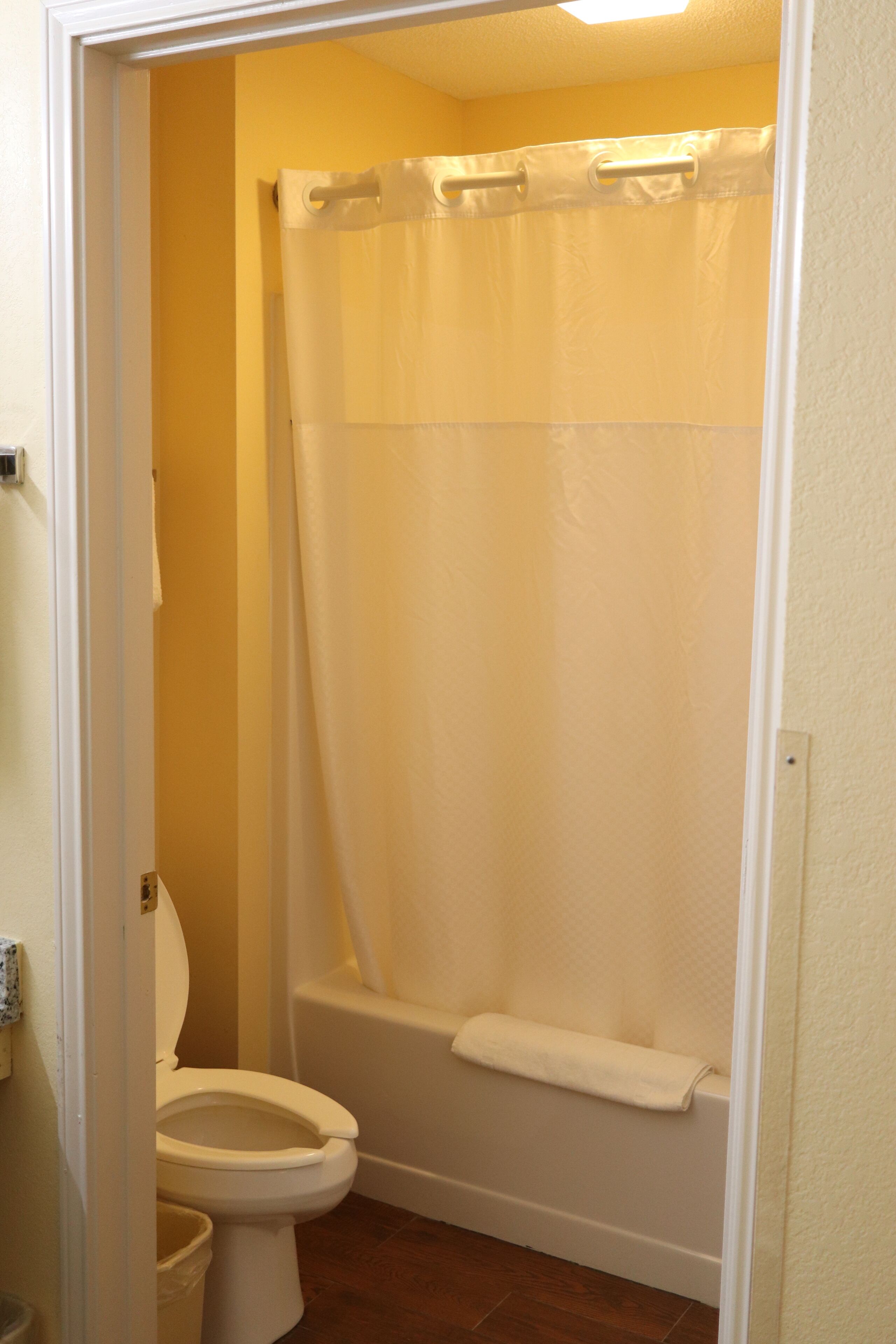 Un baño con inodoro, bañera y cortina de ducha.