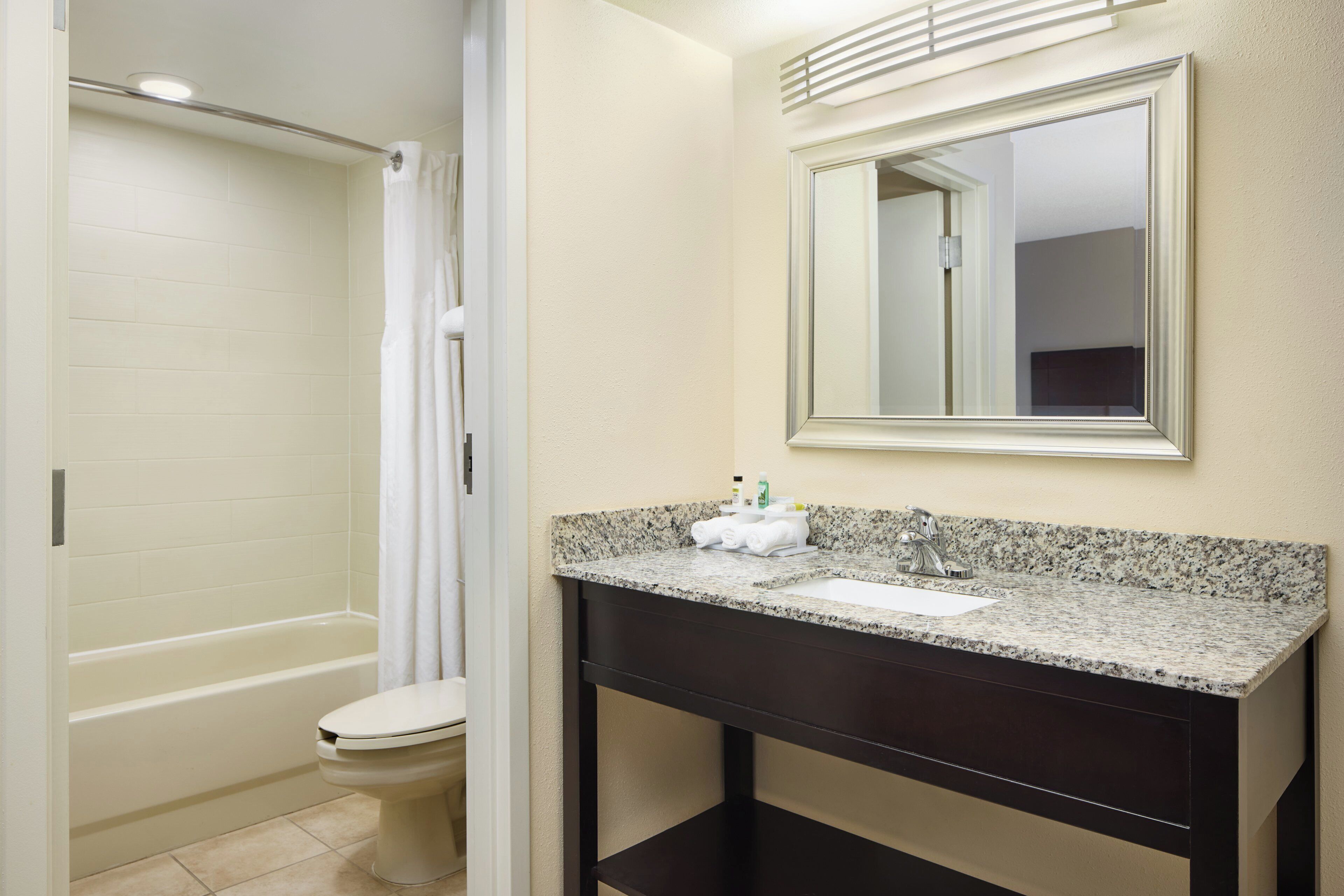 Un baño con bañera, inodoro, lavabo y espejo.