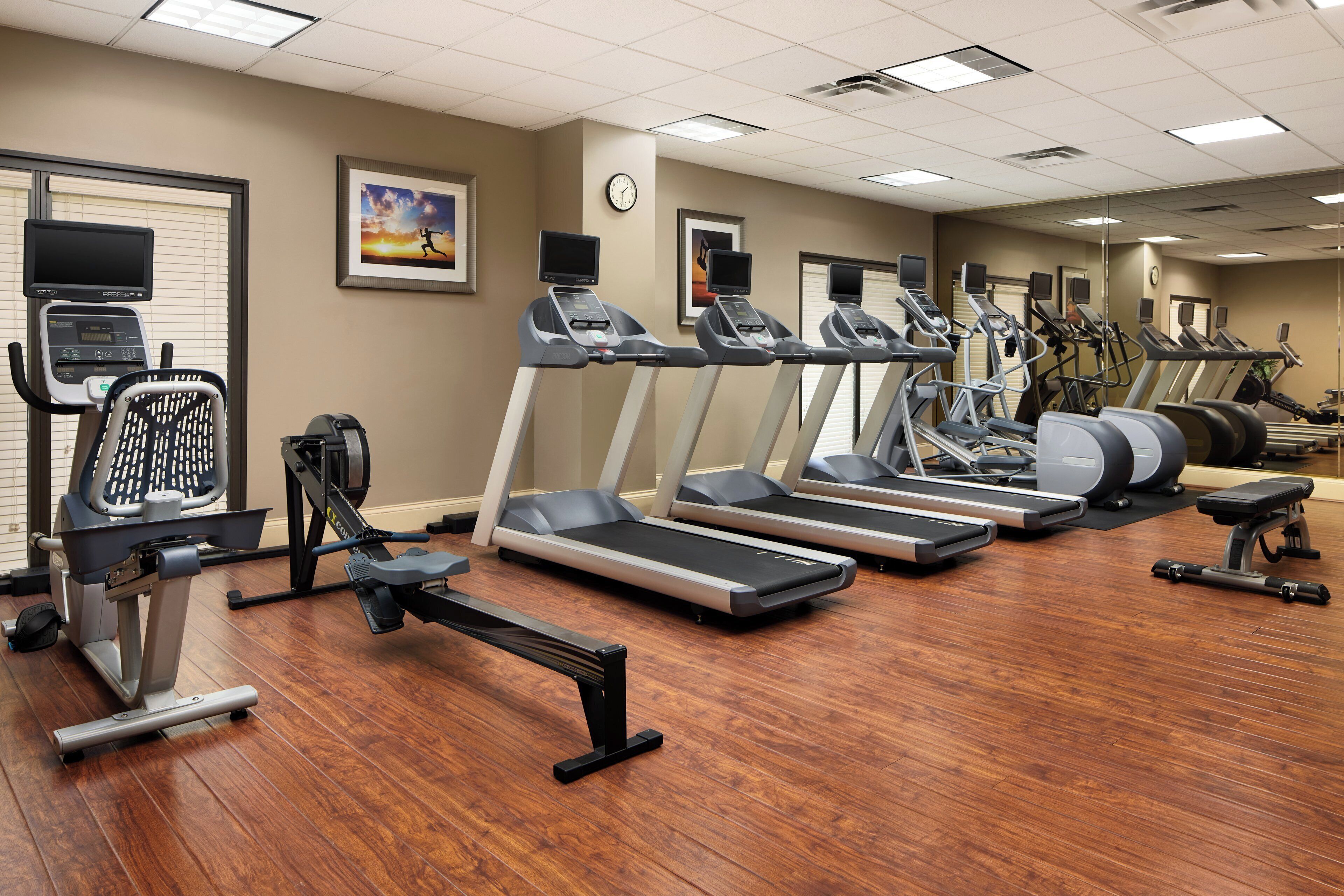 A gym with multiple treadmills, exercise bikes, and a rowing machine.