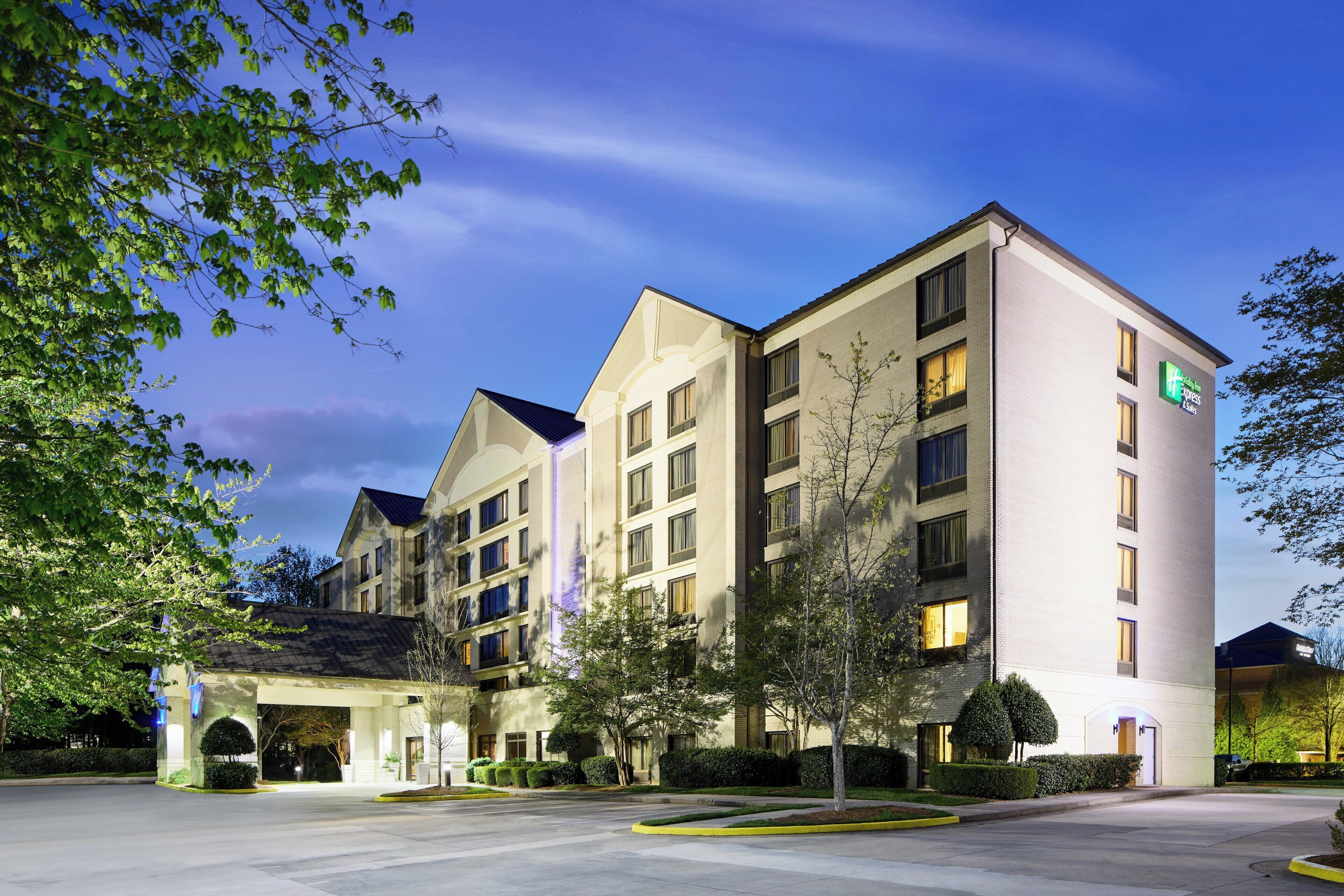 A multi-story hotel with a modern design, featuring a prominent entrance and a well-maintained landscaped area.