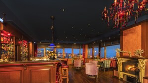 A bar area with wooden flooring, a bar counter, stools, and a large window overlooking a cityscape. - Grand Yavuz Hotel (Istanbul)