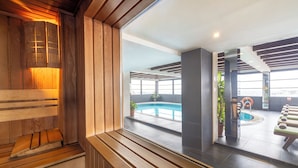 A modern indoor pool area with wooden paneling and a view of the pool through a glass partition. - AHC Old City Hotel (Istanbul)