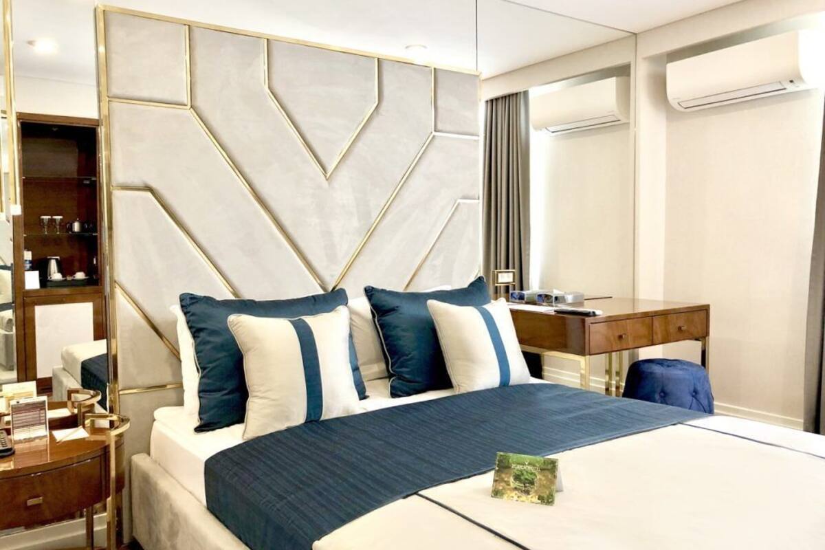 Una habitación de hotel moderna con una cama grande, un escritorio y un armario.