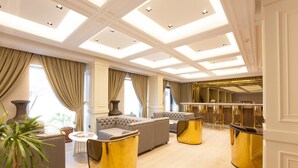 Un salón lujoso con techo alto, asientos cómodos y una zona de bar.