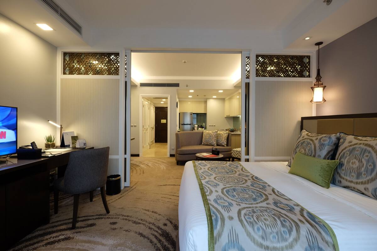 Una habitación de hotel con cama, escritorio y vistas al salón.