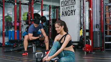 A gym with weightlifting equipment and a motivational quote on the wall.
