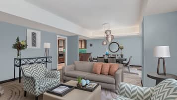 A modern living room with a sofa, armchairs, and a coffee table. There is a dining area with a table and chairs.