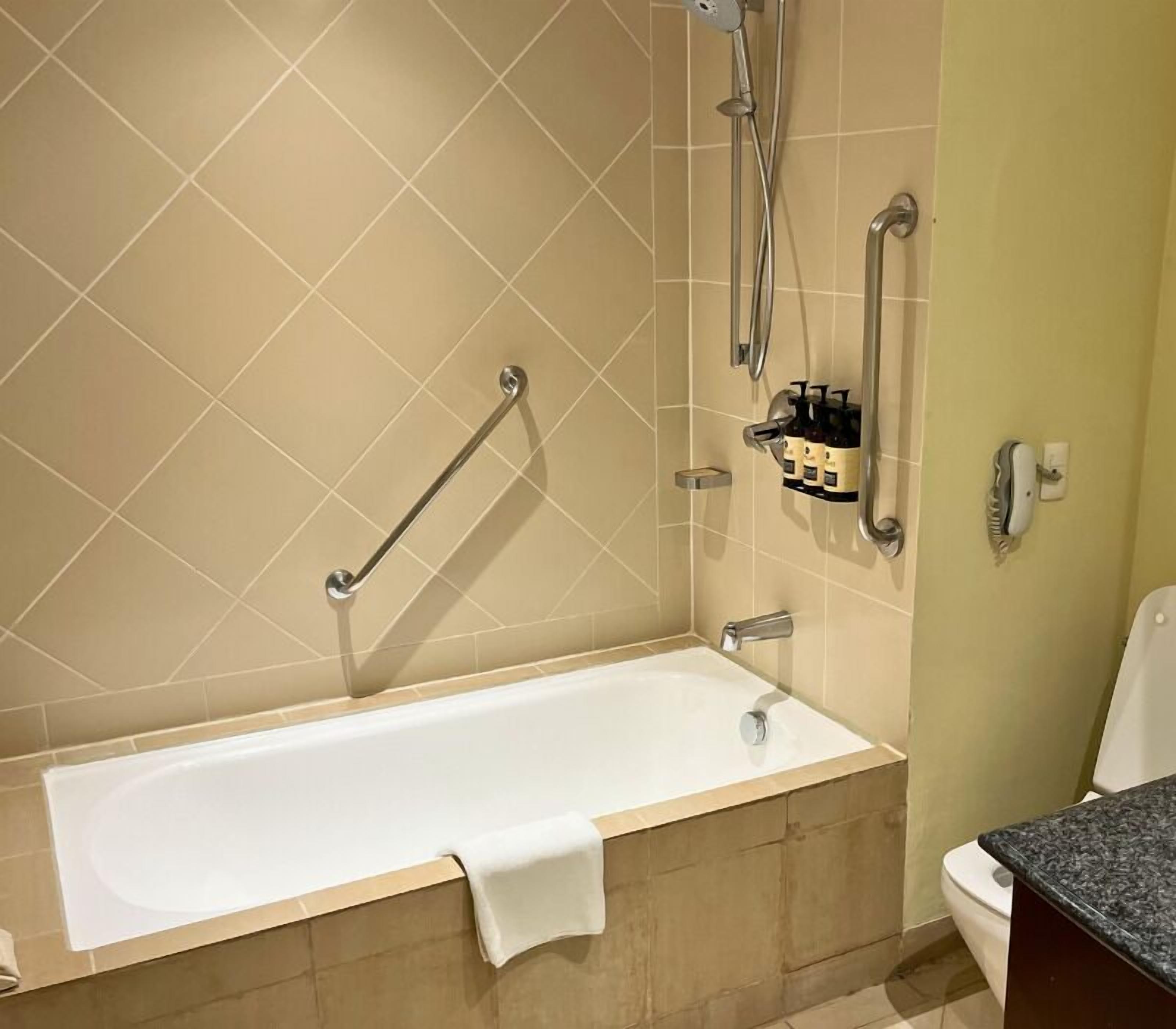 Un baño con bañera, ducha e inodoro.