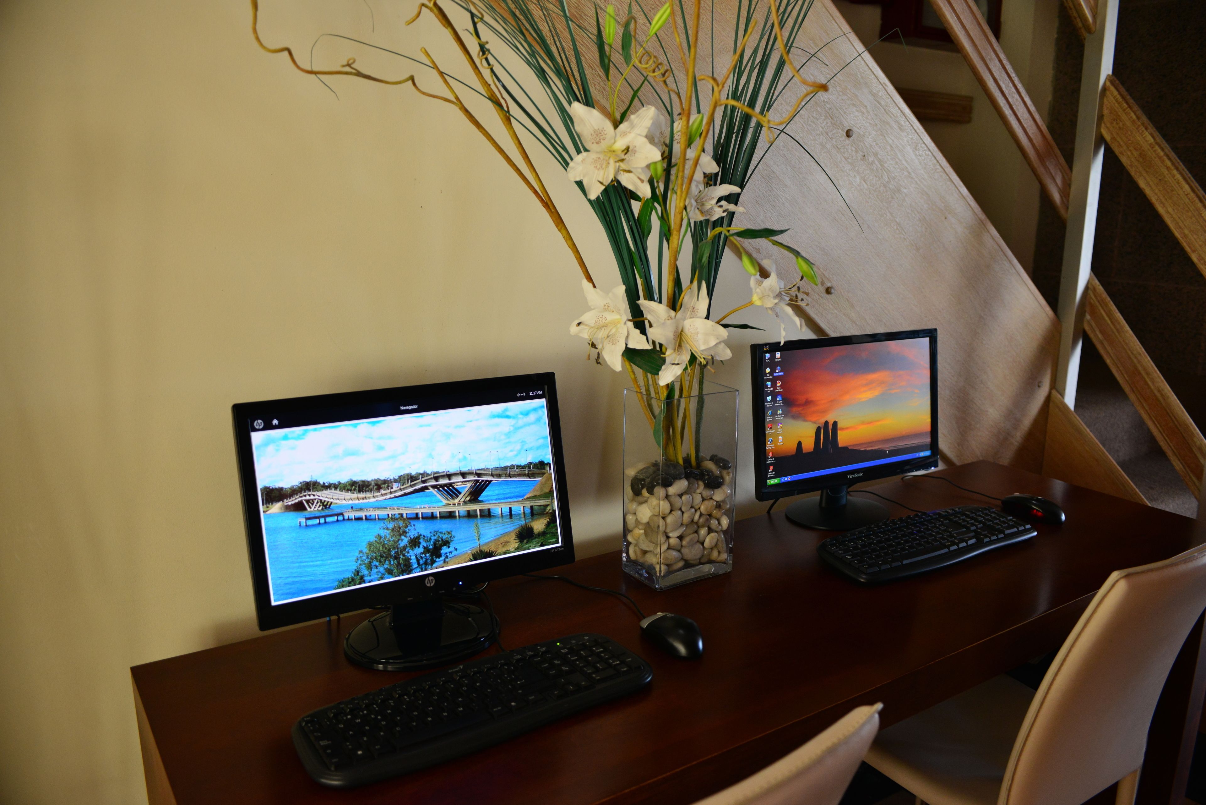 Un bureau en bois avec deux écrans, un clavier et une souris.