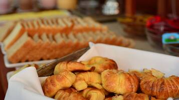 Una mesa de buffet con diversos pasteles y sándwiches.
