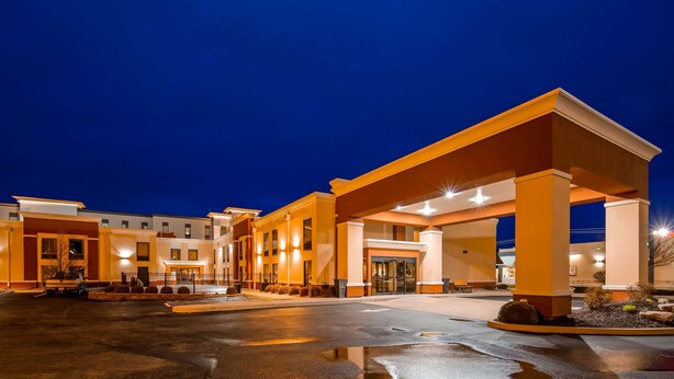 Entrada de hotel con un camino cubierto y zona de estacionamiento.