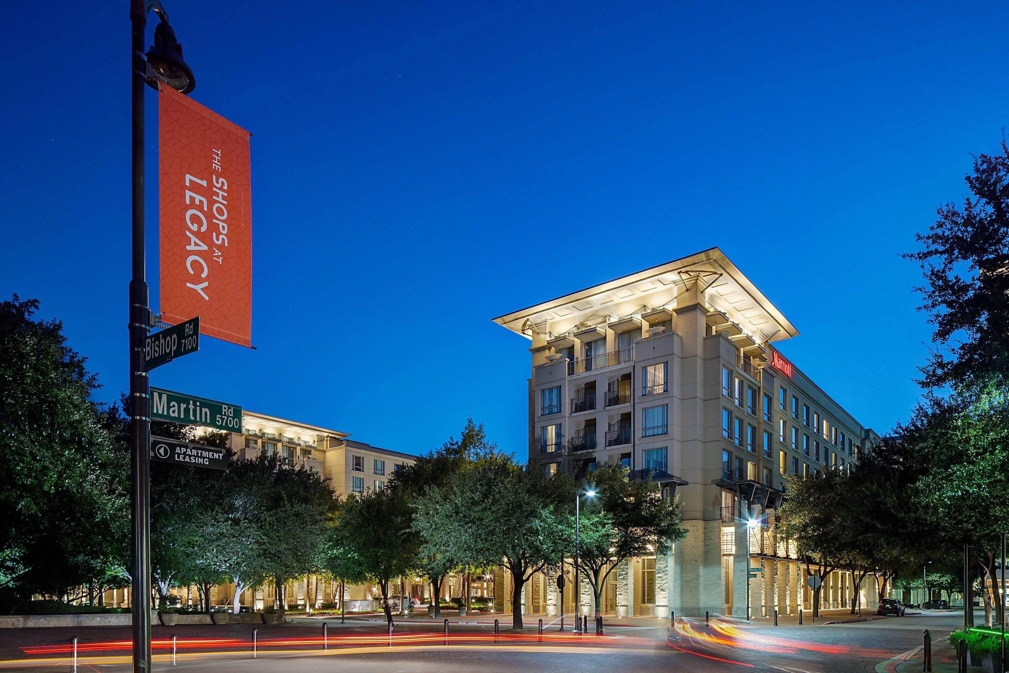 Un hotel con un llamativo letrero rojo que anuncia 'The Shops at Legacy'.