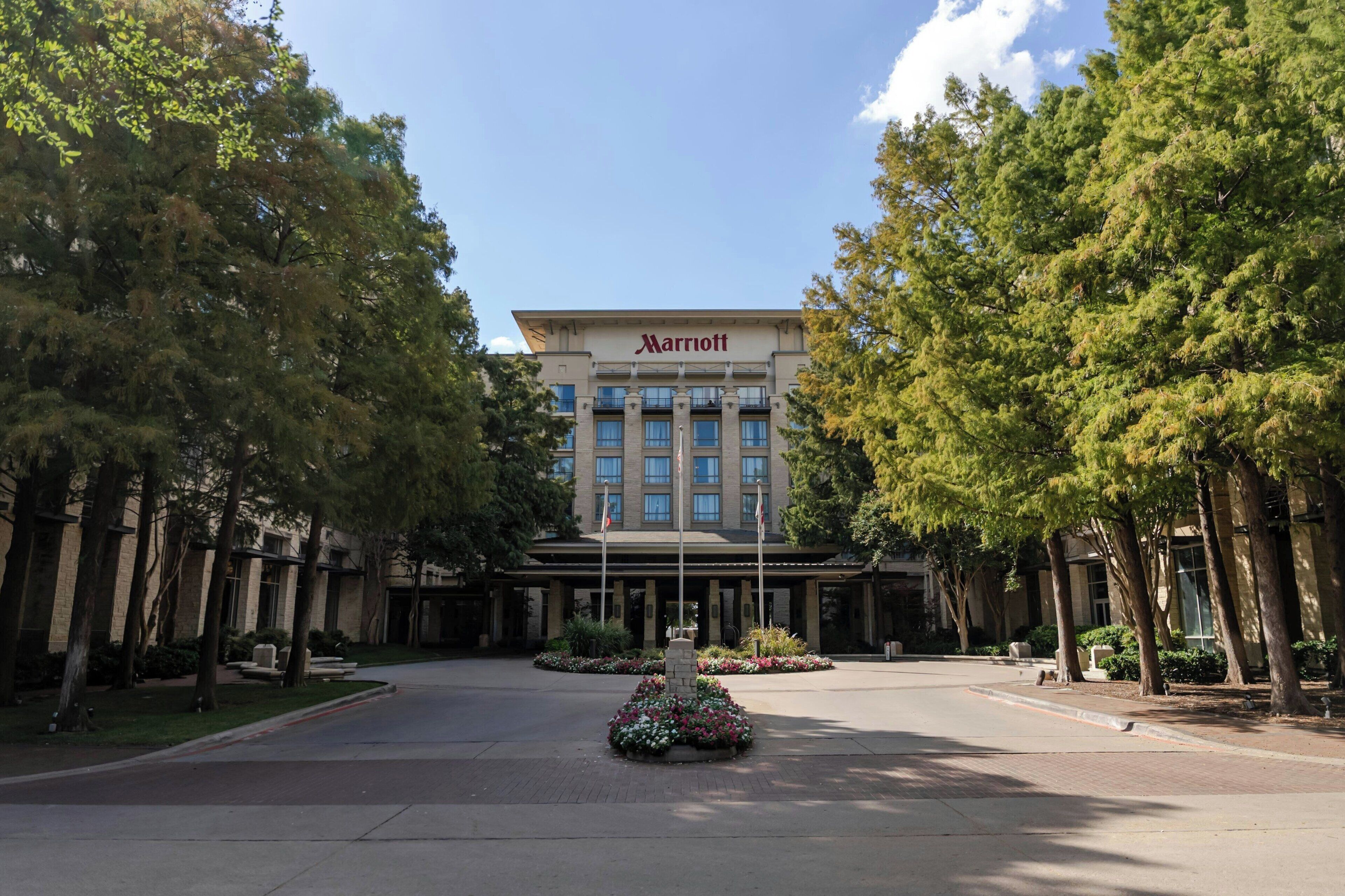 A Marriott hotel with a symmetrical facade, a central entrance, and a landscaped garden area.