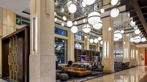 A spacious lobby with high ceilings, large windows, and a modern chandelier. - Dallas/Plano Marriott at Legacy Town Center (Plano)