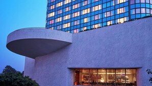 A tall hotel building with a curved facade and a prominent 'Meridien' sign at the top. - Le Meridien New Delhi (New Delhi)