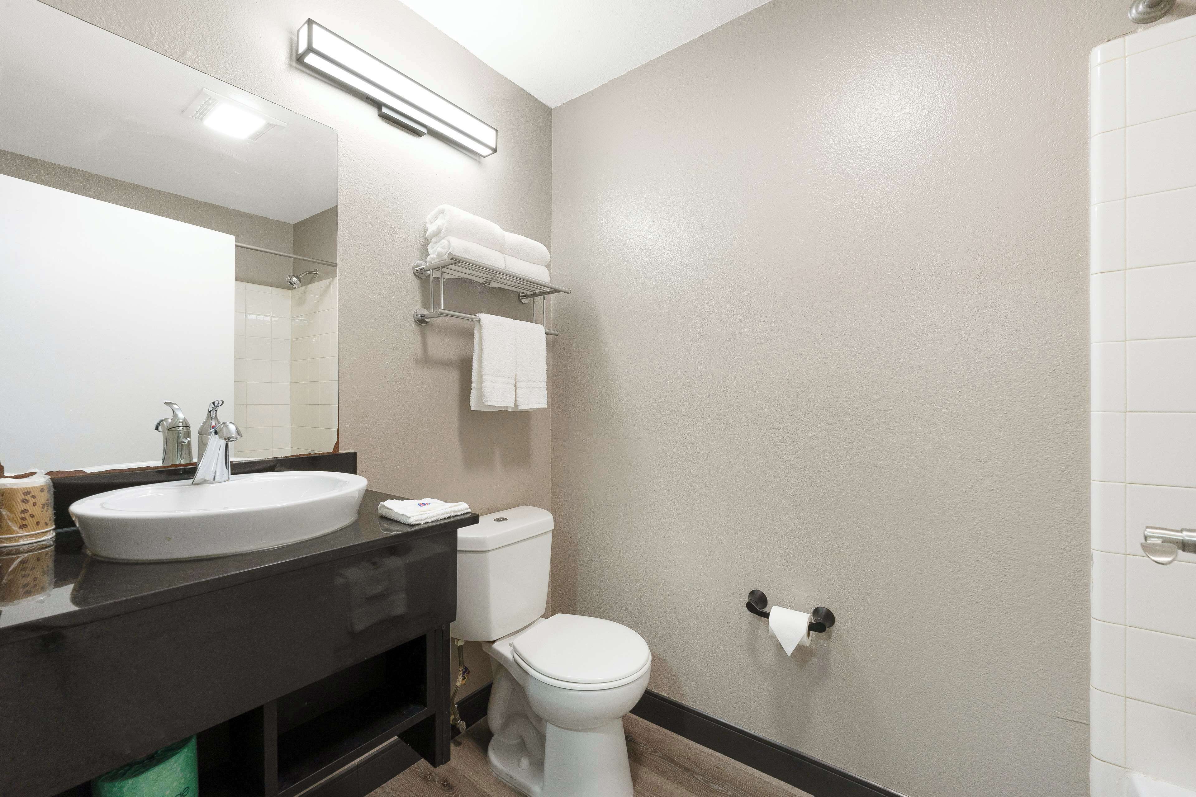 A bathroom with a sink, toilet, and towel rack.