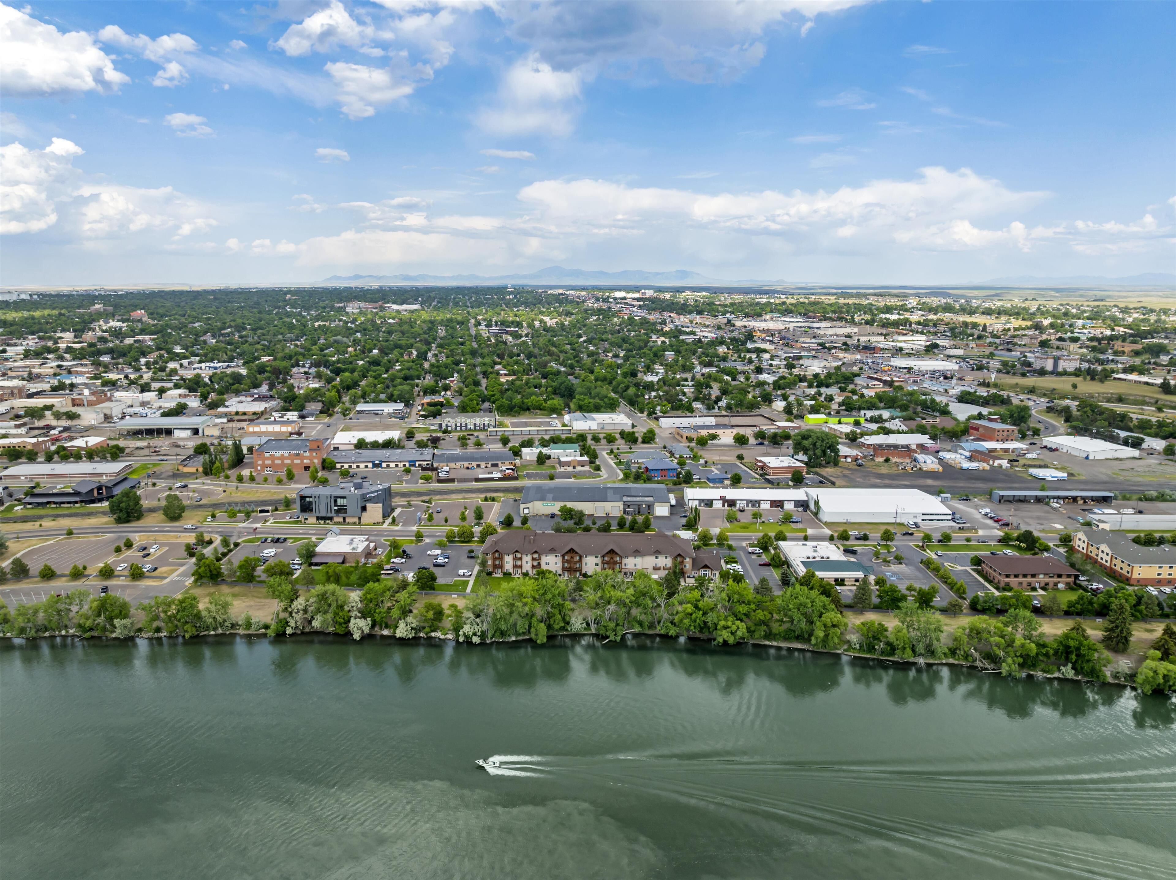 Un pueblo con un río, edificios y una embarcación.