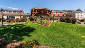 A hotel with a central courtyard, a covered outdoor seating area, and a well-maintained lawn. - Quality Inn & Suites Coeur d'Alene (Coeur d'Alene)