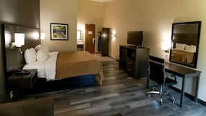 A hotel room with a bed, desk, TV, and a mirror. - Danbury Inn & Suites (Danbury)