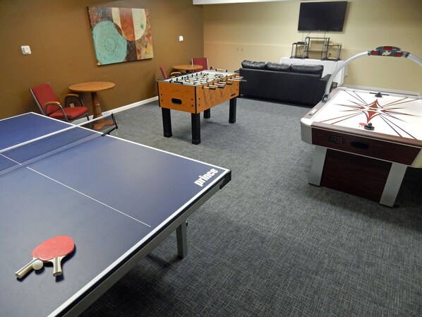 Enjoy a game night in with a ping pong table and foosball table, plus a cozy seating area with a sofa and TV.