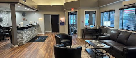 A reception area with a counter, seating, and a view of the outside.