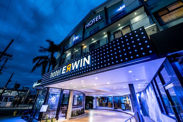 Experience the sleek, modern design of EAWIN Hotel's curved entrance and glass windows.