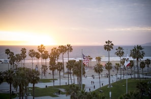 A beach scene with palm trees, an American flag, and a sunset.