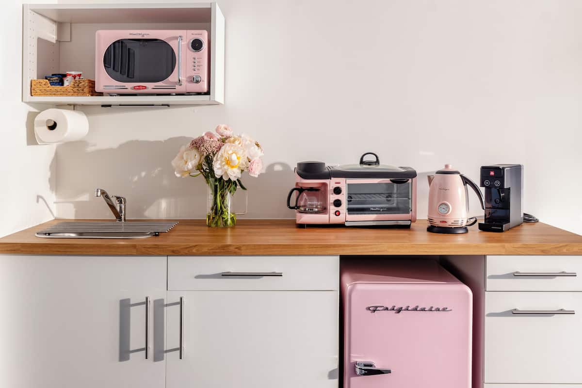 A kitchenette with a microwave, toaster, coffee maker, and a mini fridge.