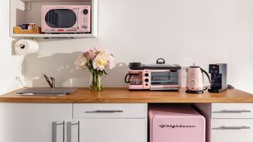 A kitchenette with a microwave, toaster, coffee maker, and a mini fridge.