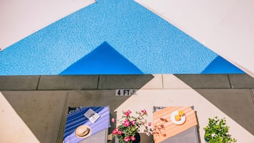 Una piscina al aire libre, sombrillas, sillones reclinables de piscina