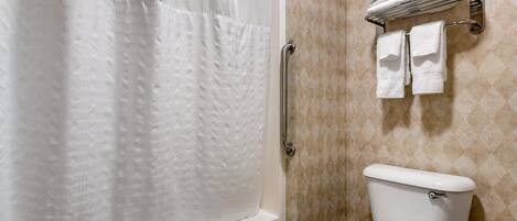 Un baño con bañera, inodoro y toallero.