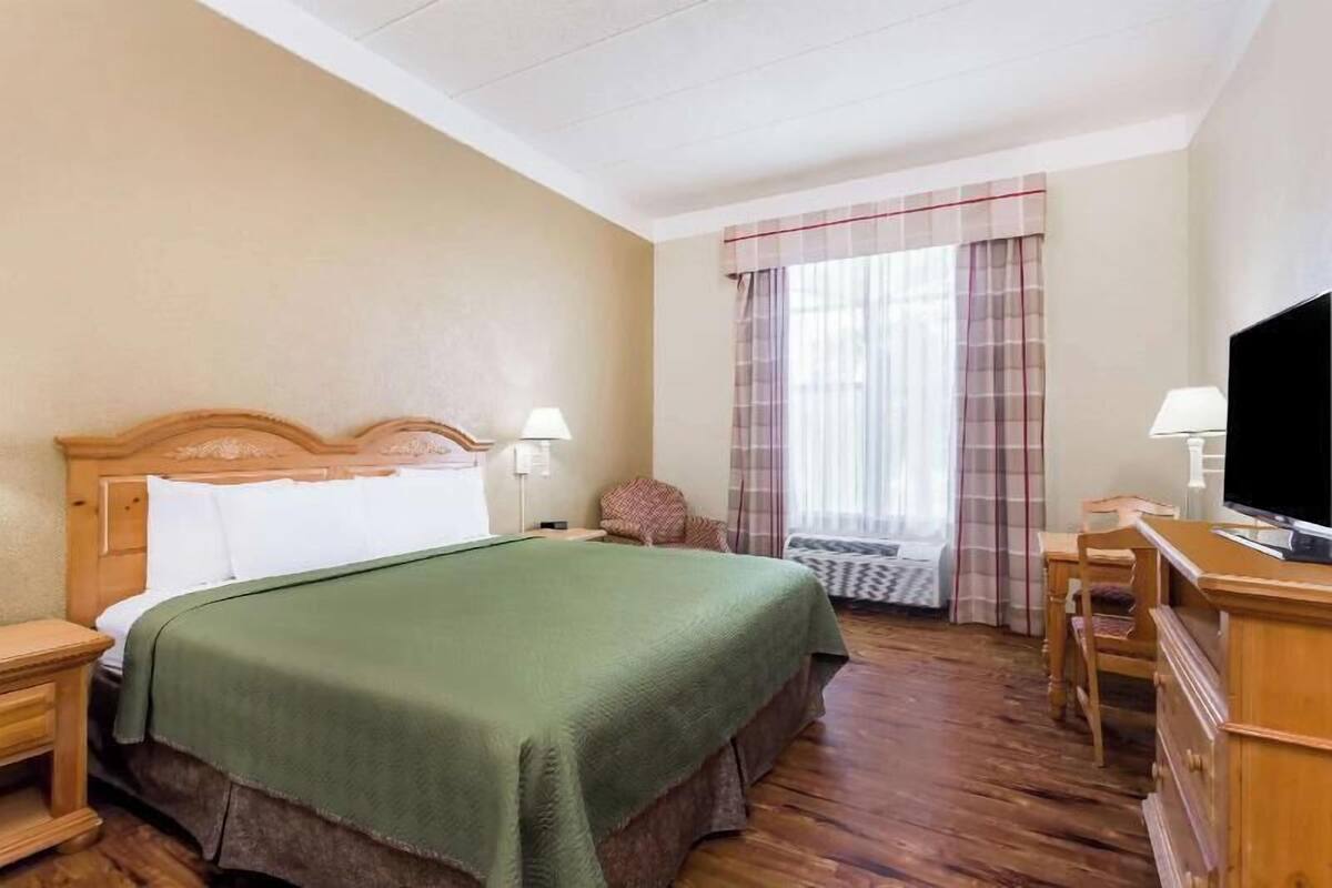 Une chambre d’hôtel équipée d’un lit, d’une télévision, d’un bureau et d’une chaise.