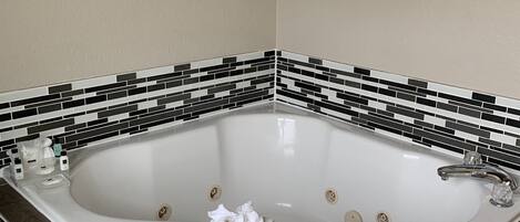 A modern bathroom with a freestanding bathtub, a built-in sink, and a tiled floor.