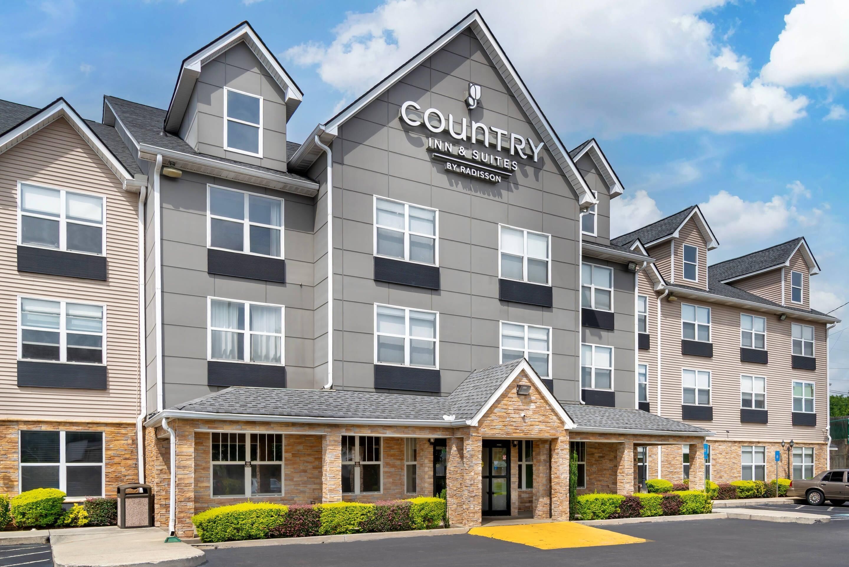 Een meerlaags hotel met een modern ontwerp, met een opvallend bord voor 'Country Inn & Suites by Radisson'.