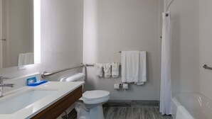 A modern bathroom with a white sink, toilet, and bathtub. There are towels hanging on a rack and a shower curtain. - Holiday Inn Express Alpharetta - Roswell by IHG (Alpharetta)