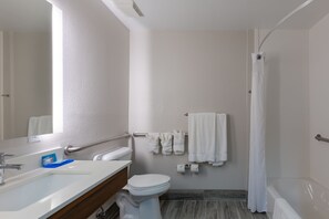 A modern bathroom with a white sink, toilet, and bathtub. There are towels hanging on a rack and a shower curtain. - Holiday Inn Express Alpharetta - Roswell by IHG (Alpharetta)
