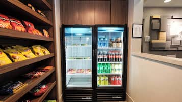 Un petit réfrigérateur pour les collations et les boissons, doté de plusieurs étagères, notamment pour les chips et les boissons en bouteille.