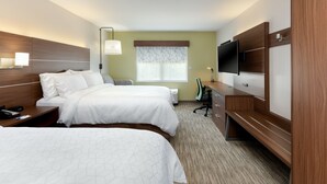 A hotel room with two beds, a desk with a flat-screen TV, a lamp, and a window with patterned curtains. - Holiday Inn Express Alpharetta - Roswell by IHG (Alpharetta)