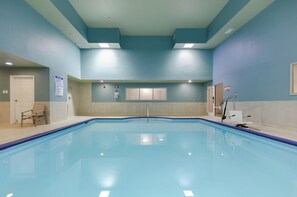 A swimming pool with a tiled deck, a door, and a chair. - Holiday Inn Express Alpharetta - Roswell by IHG (Alpharetta)