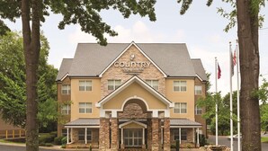 Een Country Inn & Suites gebouw met een stenen gevel, meerdere ramen en een centrale ingang.