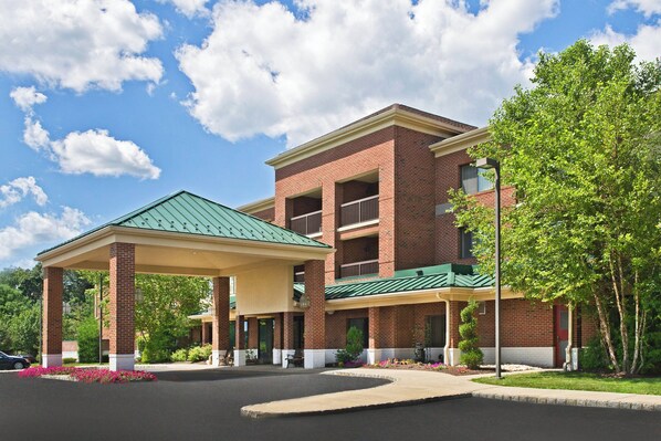A multi-story hotel with a covered entrance and a brick facade.
