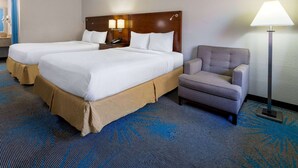 A hotel room with two beds, a chair, a nightstand, and a lamp. - Days Inn by Wyndham Columbia (Columbia)