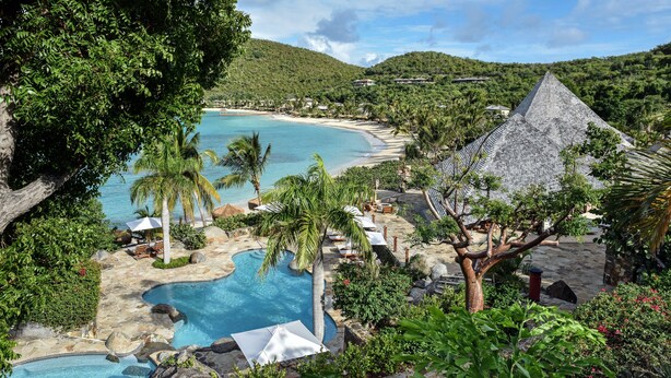 Un resort con piscina, playa y una estructura con forma de pirámide.