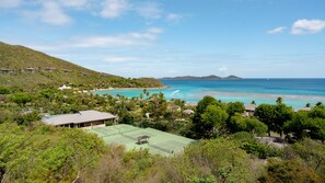A coastal resort with a tennis court, beach, and ocean views.