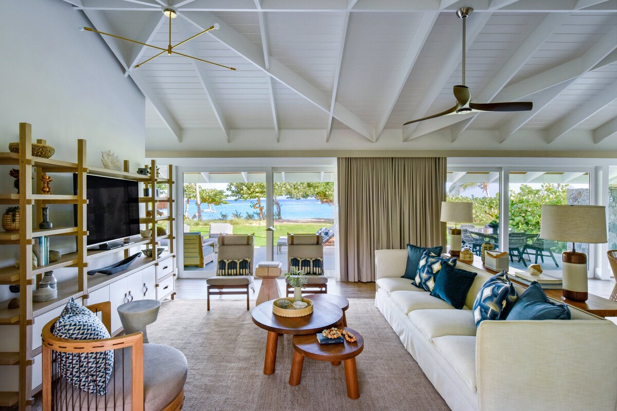 A spacious living room with a large TV, comfortable seating, and a view of the outdoors.