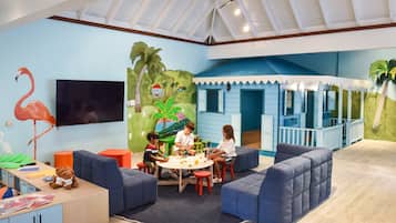 A children's playroom with a mural, seating, and a TV.