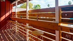 An outdoor seating area with wooden benches and tables, a clear view of the sky, and a sign that reads "NO BEVERAGE."