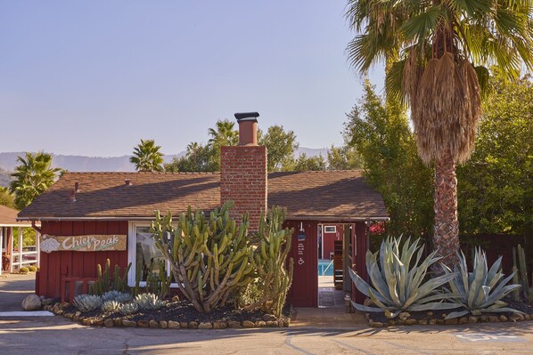 A building with a red exterior, a brick chimney, and a sign that reads "Chief Peak."