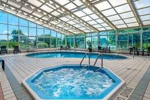 A covered swimming pool with a hot tub, seating area, and a view of the surrounding greenery. - Comfort Inn Anderson South (Anderson)