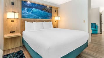 Una cama grande con ropa blanca, cabecera de madera y dos lámparas fijadas a la pared.